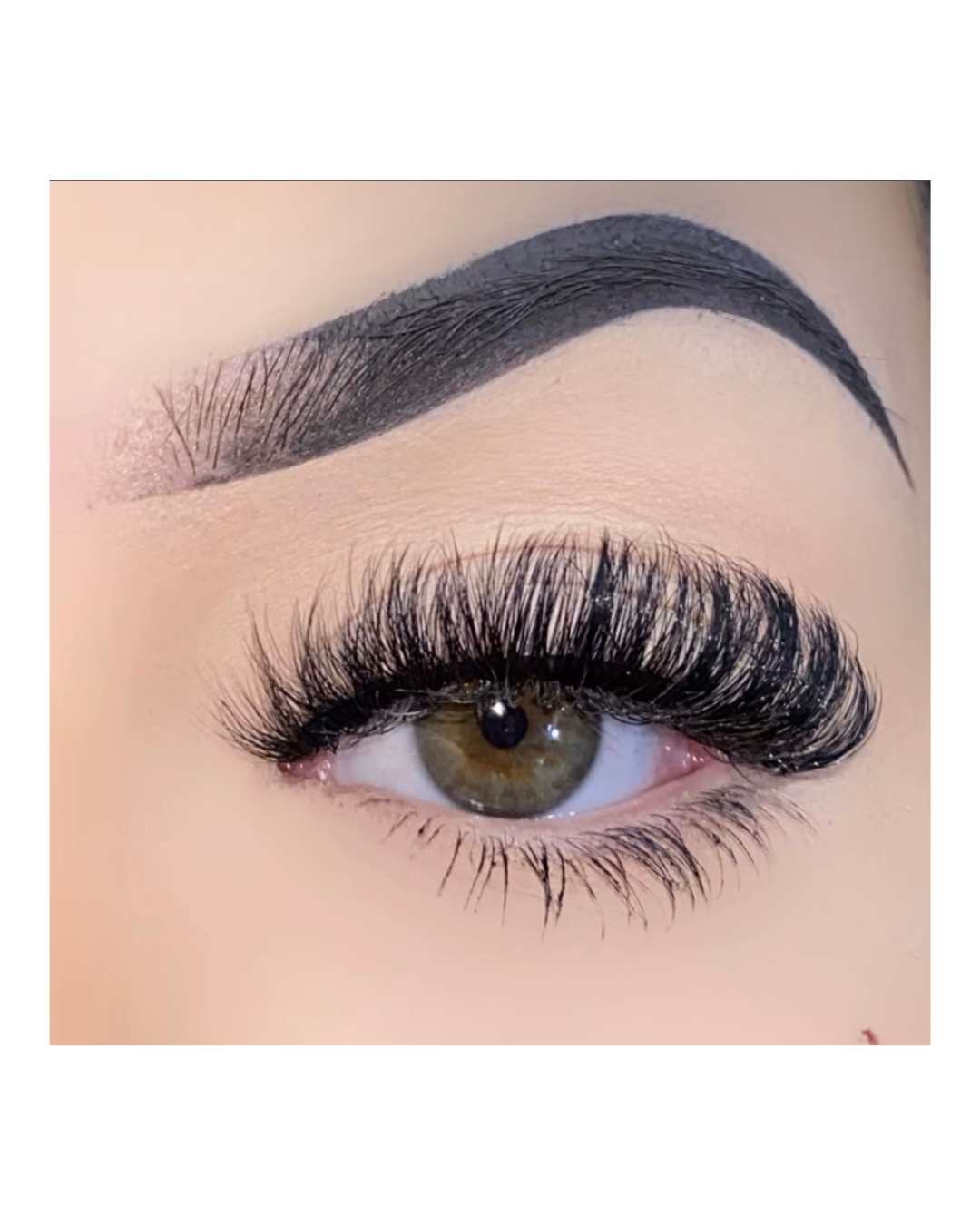 Close-up of an eye with long, dark eyelashes and a well-groomed eyebrow.